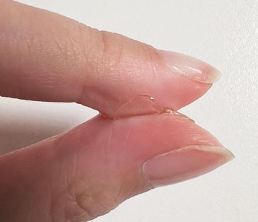 Close-up of a person's two fingers with Sticky tabs pro on a white background