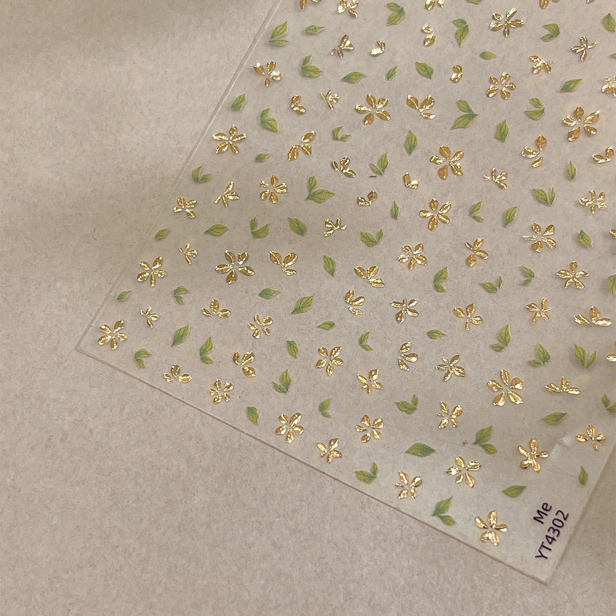 3D gold-foil floral nail stickers with metallic petals and leaves, close up look