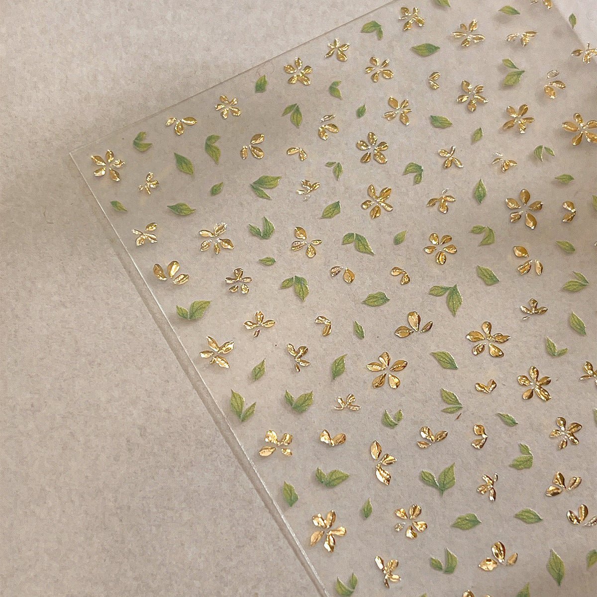 3D gold-foil floral nail stickers with metallic petals and leaves for DIY nail art, close up look angle 2