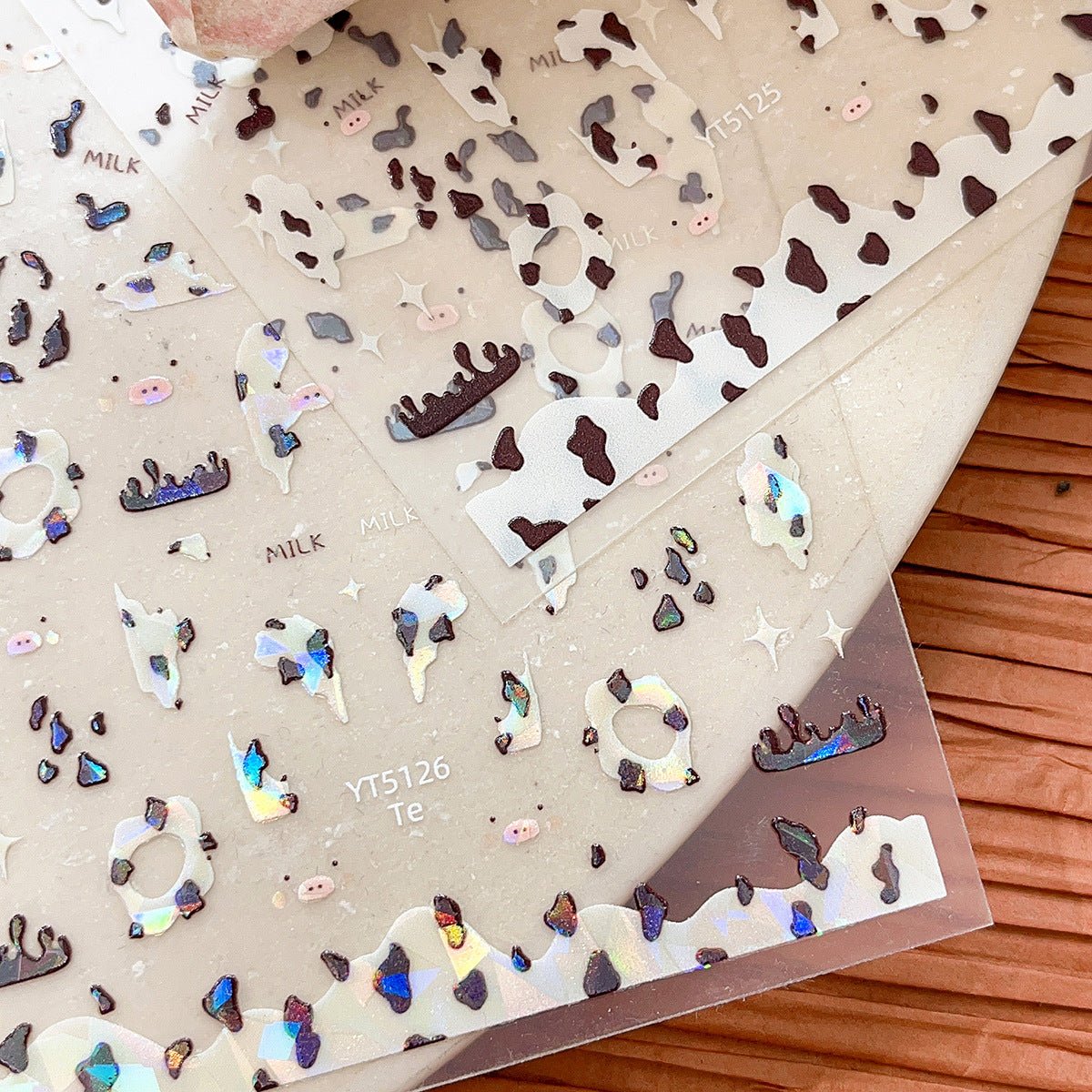 Close up look on Shell shine cow print nail decals with pearlescent finish and 3D embossed cow print nail stickers in white and brown