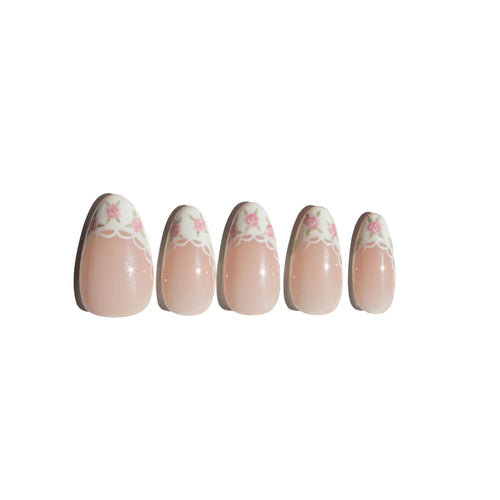 Set of five coquette nail art designs with hand-painted pink floral patterns on a white background. LuxeCharm press on nails