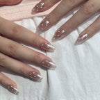 Close-up of hands with almond-shaped nails featuring a clear coat and white polka dot design on a white background. LuxeCharm