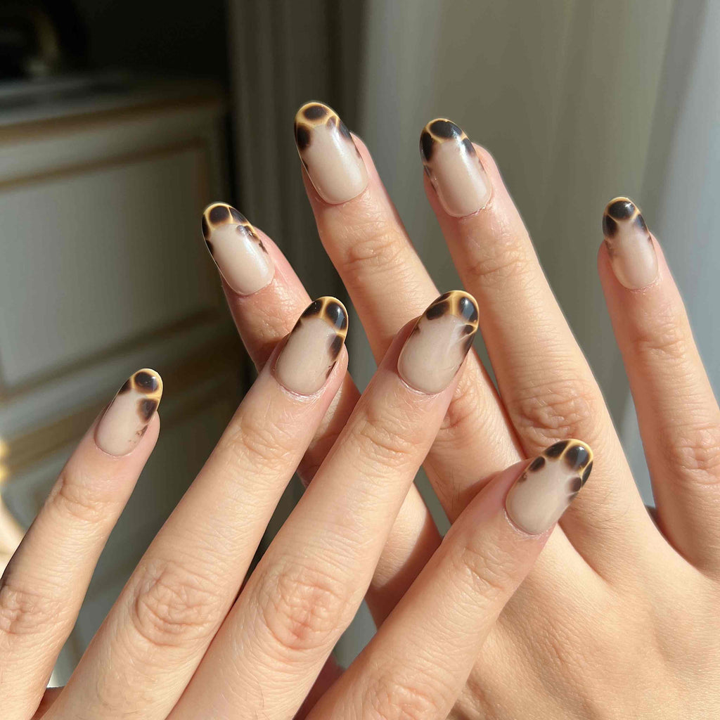 LuxeCharm Glazed Amber press-on nails worn on hand, featuring tortoiseshell pattern and a glazed finish