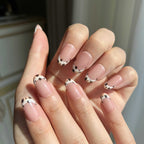 LuxeCharm Quiet Prairie cow-print inspired press-on nails styled on hand with a refined everyday look