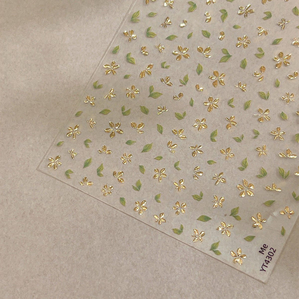 3D gold-foil floral nail stickers with metallic petals and leaves, close up look
