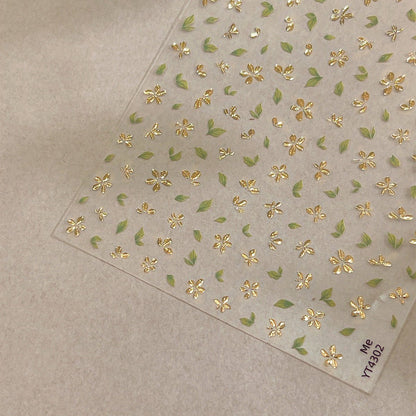 3D gold-foil floral nail stickers with metallic petals and leaves, close up look