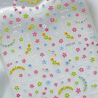 Sheet of colorful flower stickers with 'Spring' and 'bliss' text on a white background. LuxeCharm nail stickers