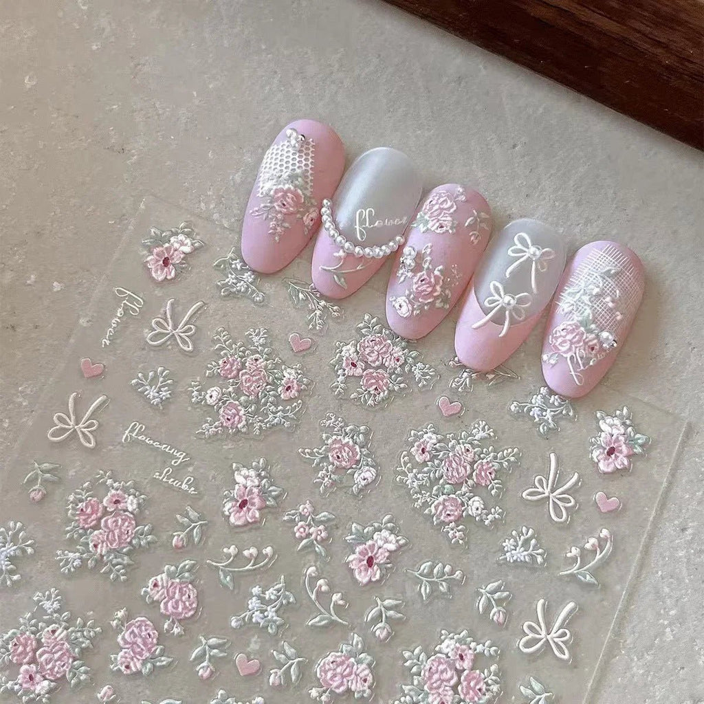 Nail art stickers with floral and bow designs on a clear sheet. LuxeCharm nail stickers