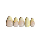Set of five fake nails with a white and yellow striped design featuring 3d lemon shape sculpted on a white background. LuxeCharm press on nails