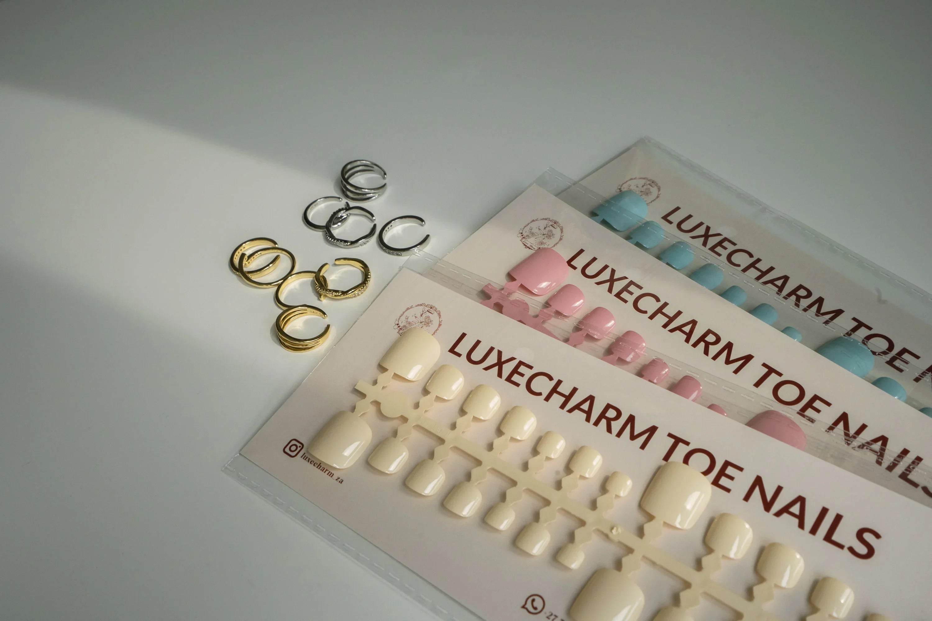 Luxecharm toenail set with various designs and toe rings on a white background