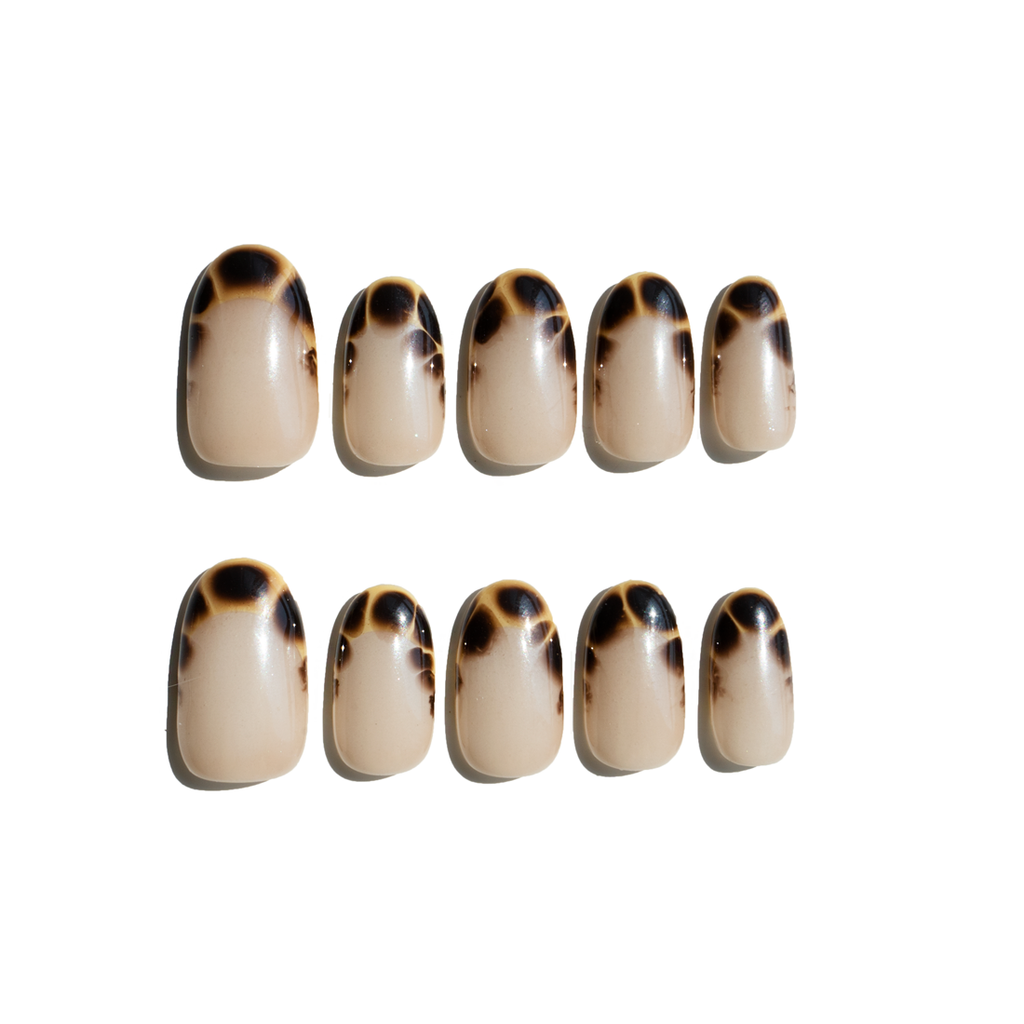 Set of ten tortoiseshell patterned LuxeCharm press on nails on a white background