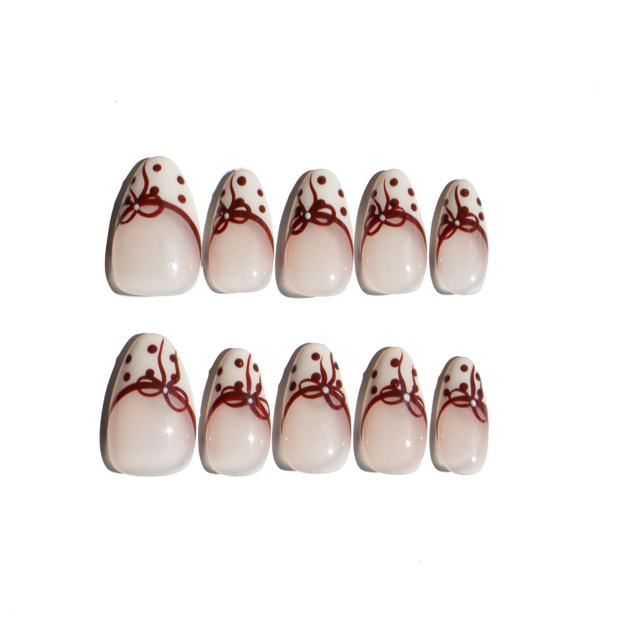 Set of LuxeCharm press on nails with red bow and polka dot designs on a white background. Ten LuxeCharm press on nails