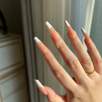 Close-up of a hand with LuxeTip French long coffin press on nails in light brown color