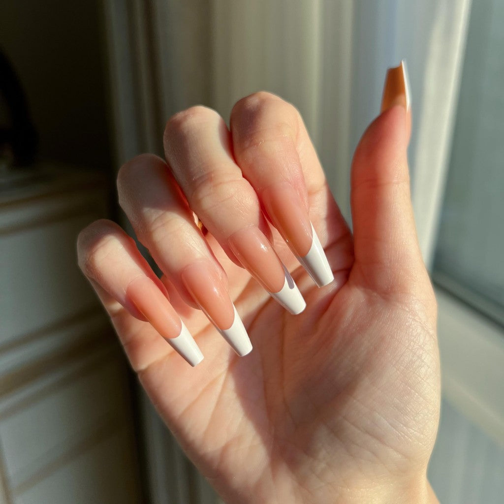 Hand with LuxeTip French long coffin press on nails in light brown color, in front of a neutral background