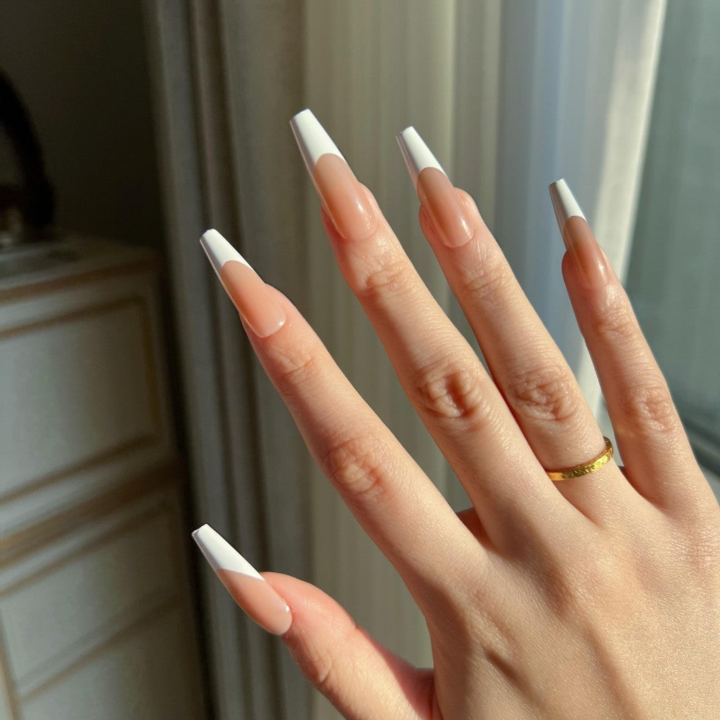 Hand with LuxeTip French long coffin press on nails in mocha color, wearing a gold ring.