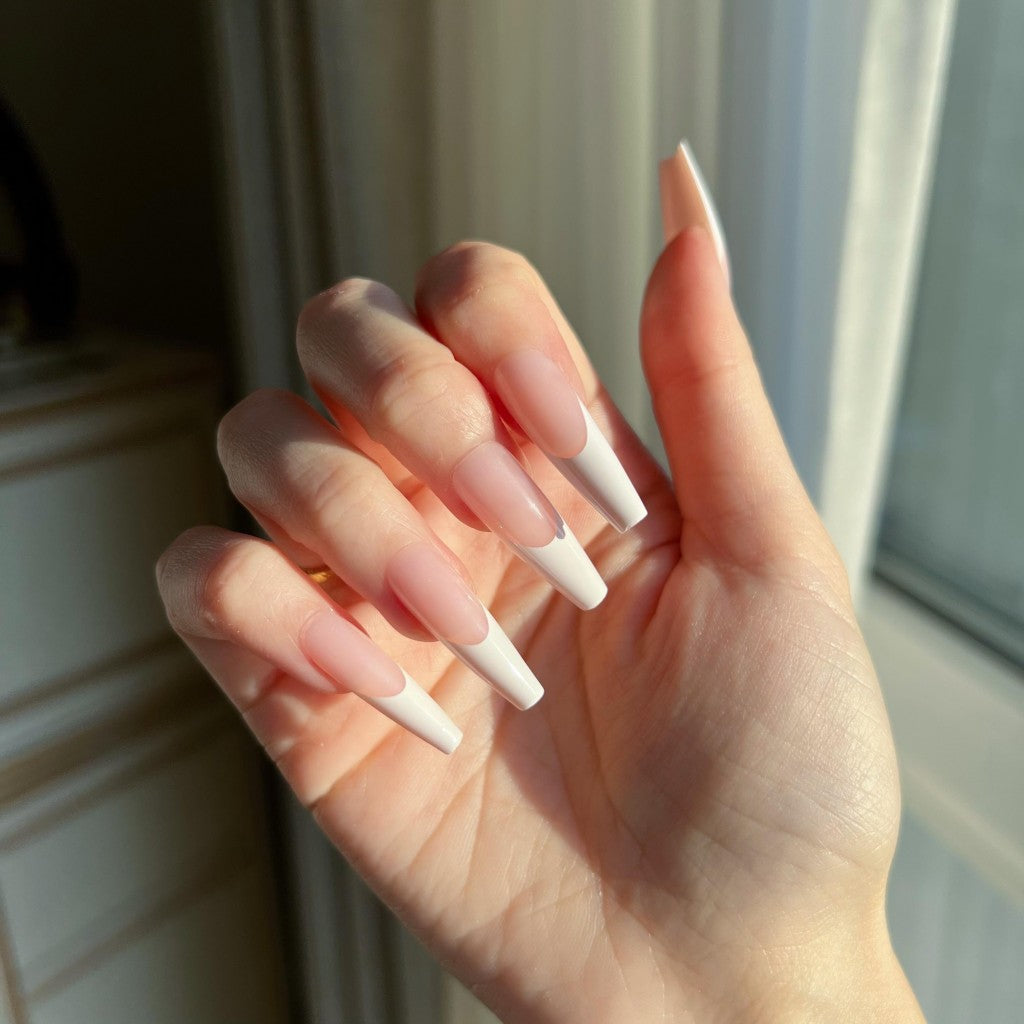 Hand with LuxeTip French long coffin press on nails in pink color against a neutral background