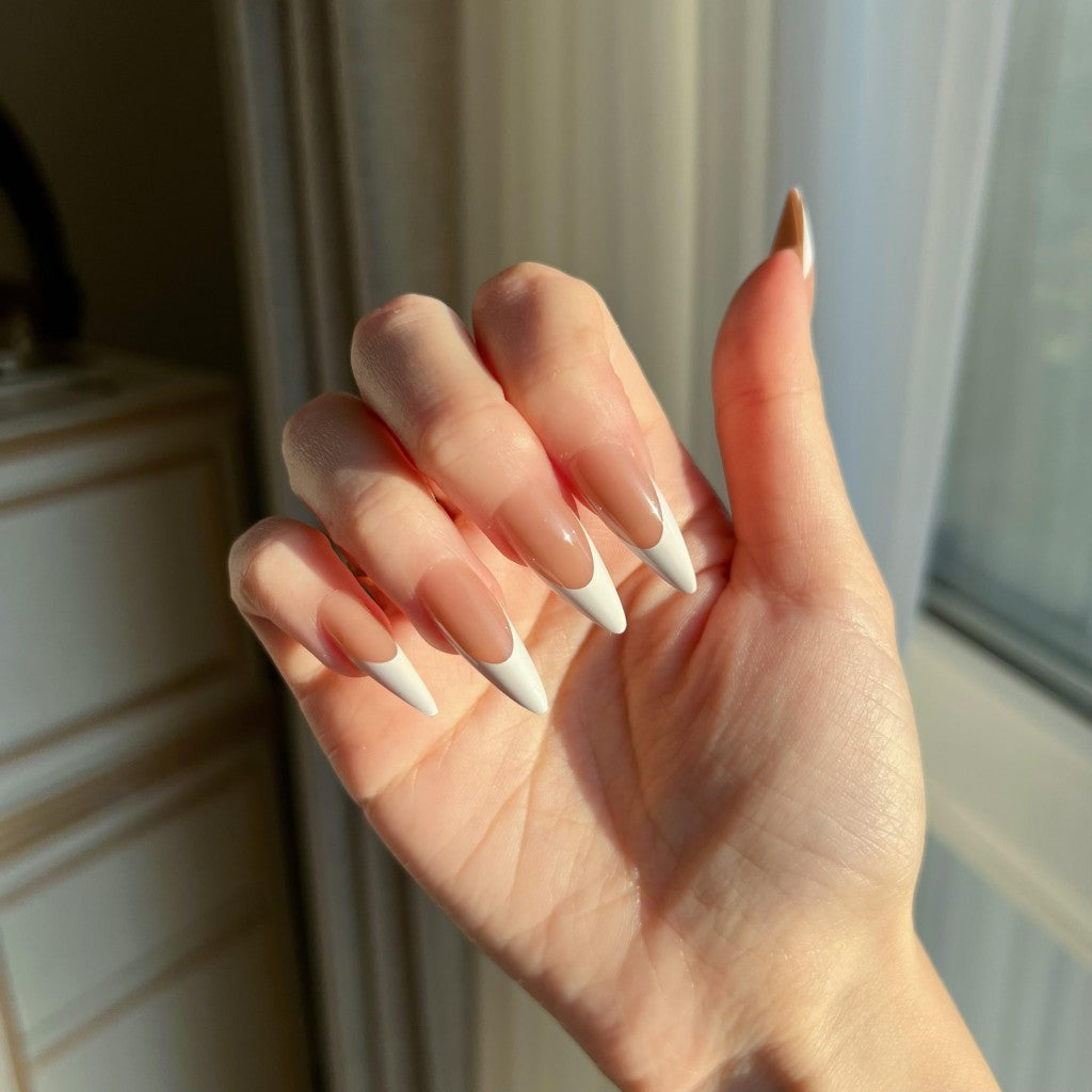 Hand with LuxeTip French long stiletto press on nails in mocha color, in a neutral setting