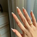 Hand with LuxeTip French medium almond press-on nails in mocha color featuring a minimalistic design, wearing a gold ring.