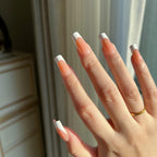 Hand with LuxeTip French medium square press on nails in light brown color, in a neutral setting