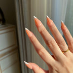 Hand with LuxeTip French medium stiletto press on nails in light brown color , wearing a gold ring.
