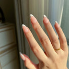 Close-up of hands wearing LuxeCharm LuxeTip French Short Almond press on nails in pink color. 