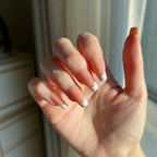 Hand with LuxeTip French short coffin press-on nails in light brown color against a neutral background