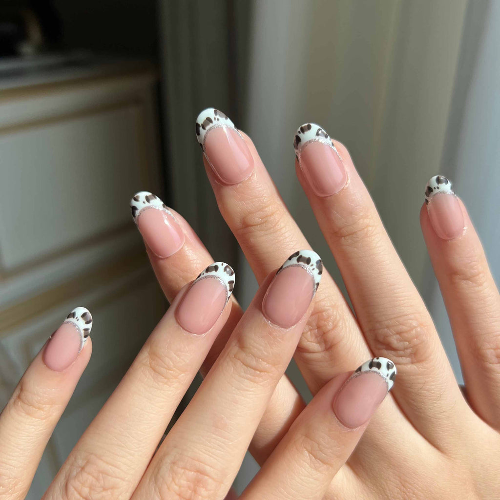 LuxeCharm Pistachio Safari animal print press-on nails styled on hand in nude, green, and silver tones