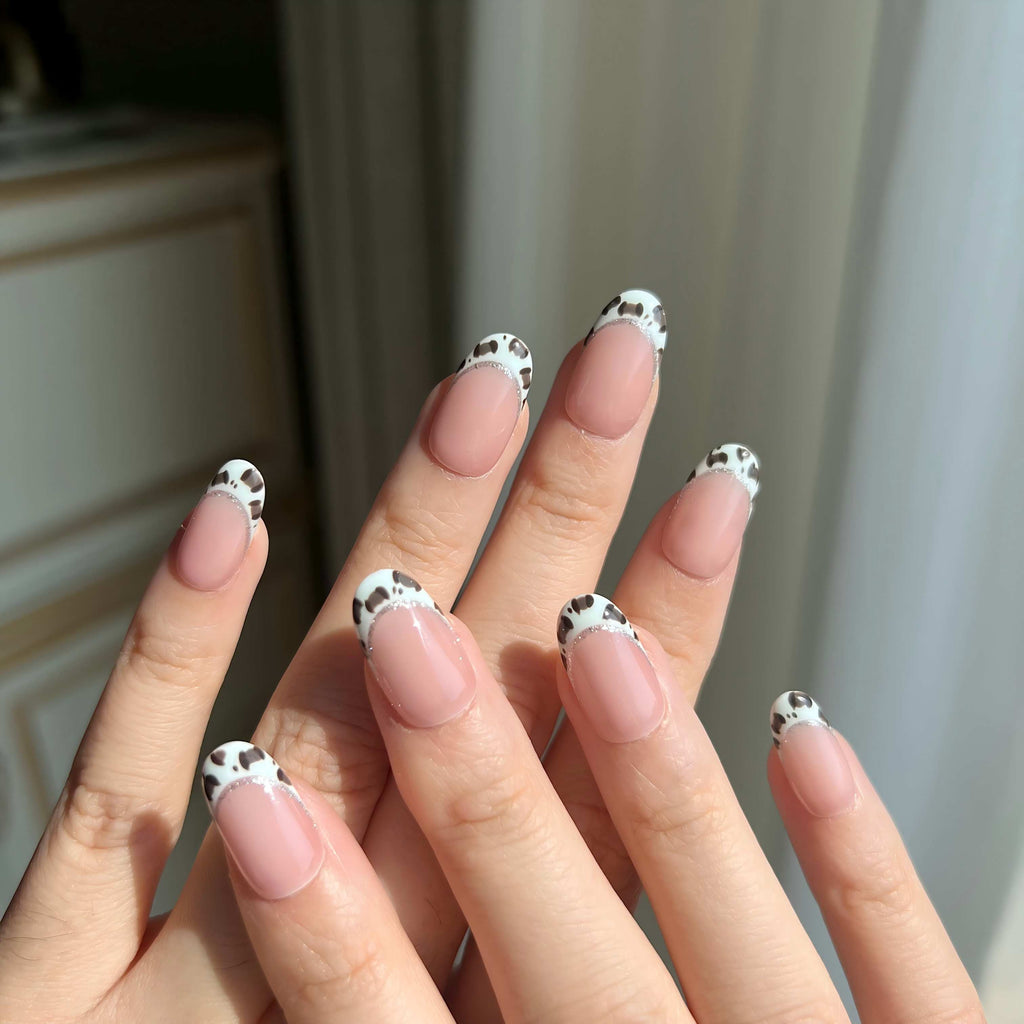 Hand wearing LuxeCharm Pistachio Safari press-on nails, short oval shape with fresh green animal print design and silver glitter edge.