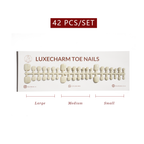 Set of LuxeCharm toe nails with size labels on a white background. Vanilla press-on toenails 42 piece set — creamy white pedicure