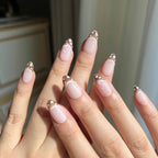 LuxeCharm Velvet Fawn press-on nails styled on hand, combining soft pink colour and delicate handcrafted detail