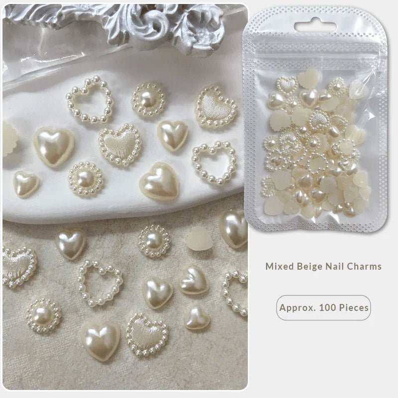 Beige nail charms with pearl details on a textured surface, next to a clear packaging bag labeled 'Mixed Beige Nail Charms'. LuxeCharm
