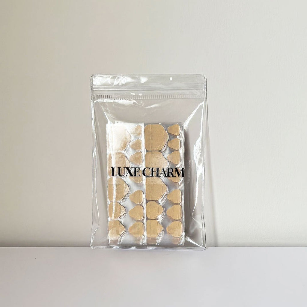 Clear packaging with sticky tabs pro for toes on a white background. LuxeCharm 